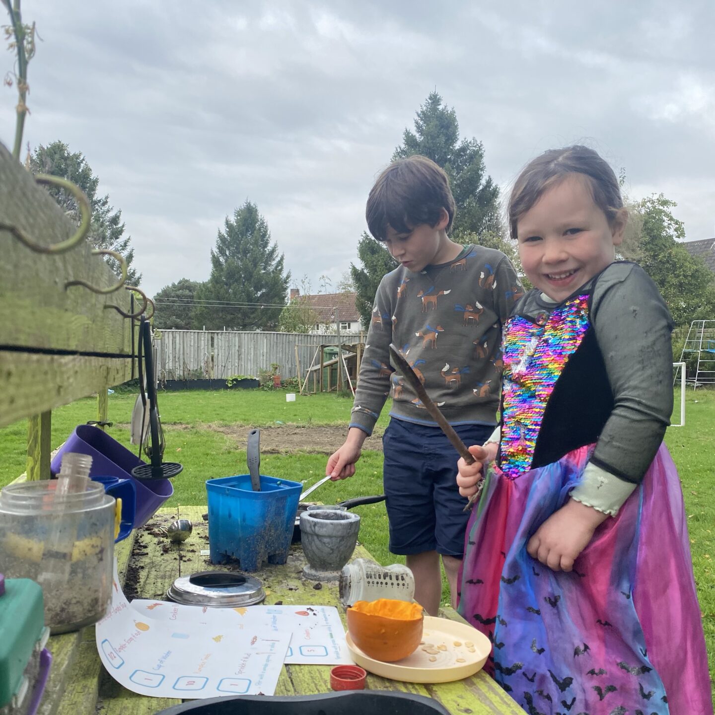 autumn activities with 2 kids playing in the mud kitchen
