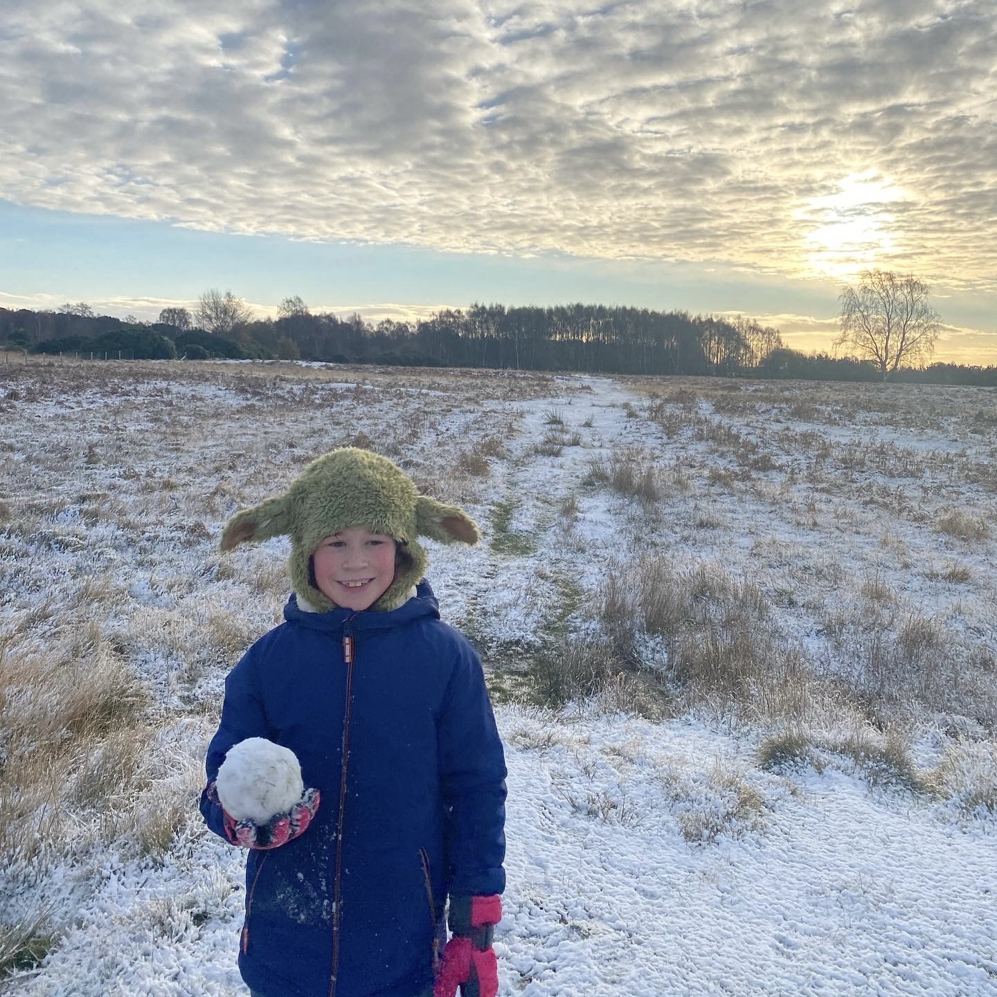 a young boy holding a snowball