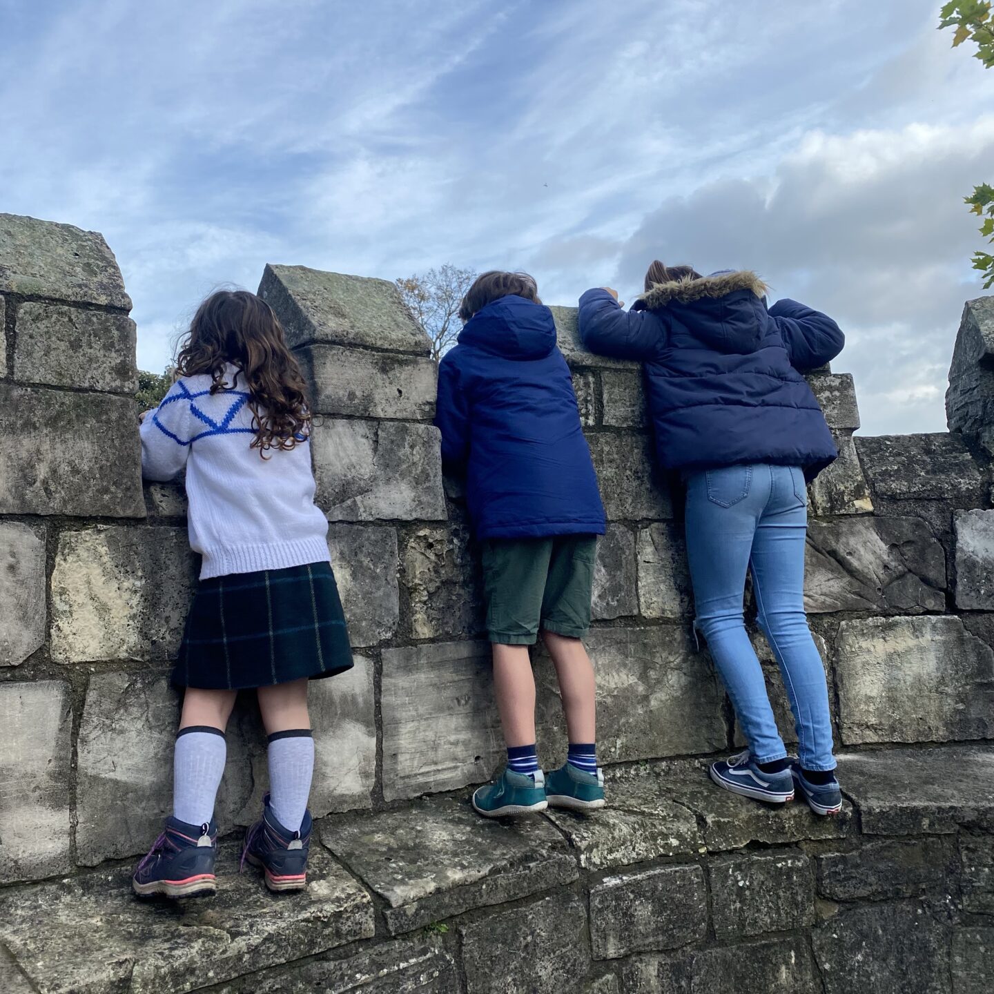 3 kids looking over the city walls of York