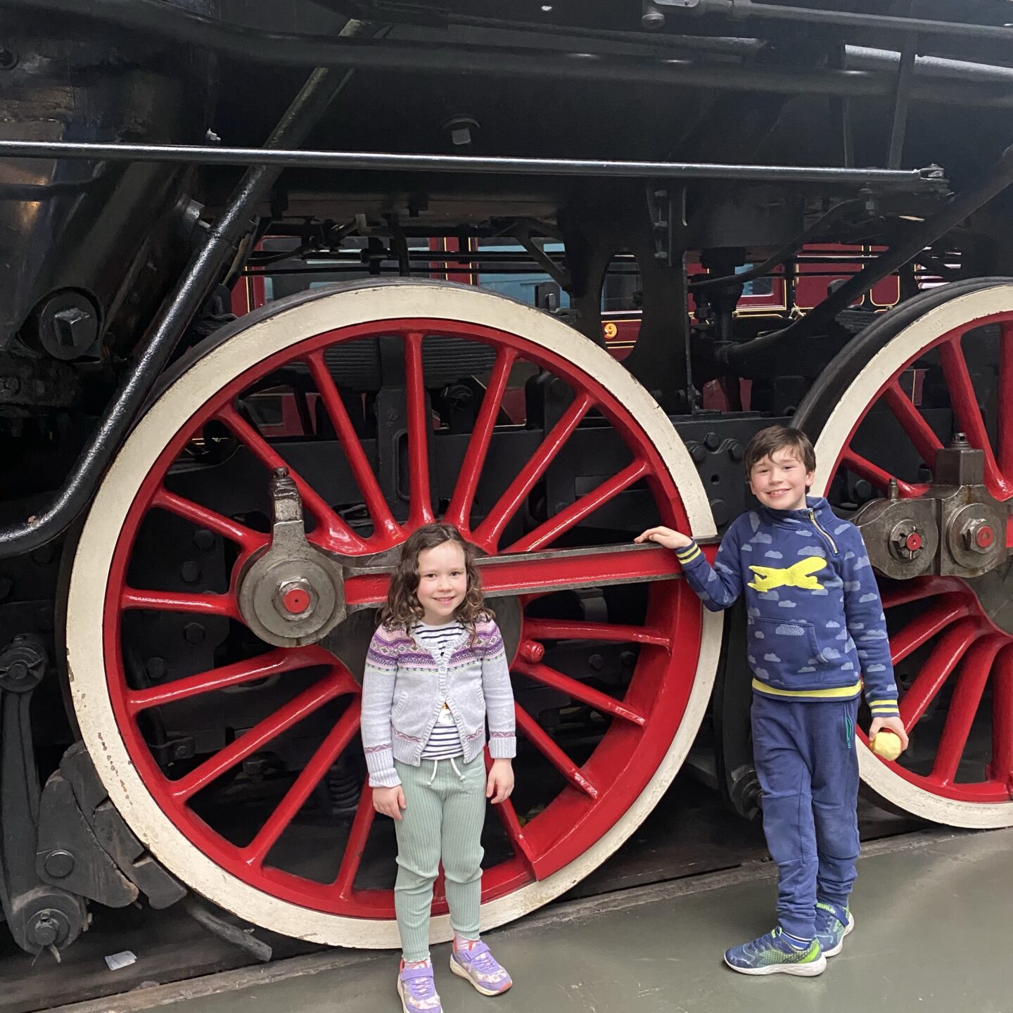 A busy week - two children stood by a large locomotive in York Railways museum
