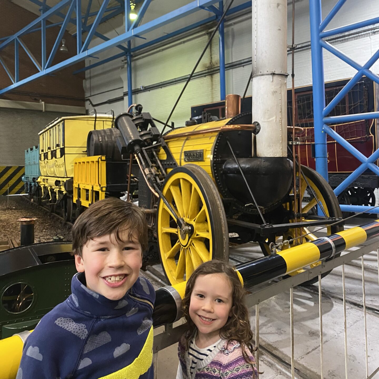 Two kids stood by the rocket