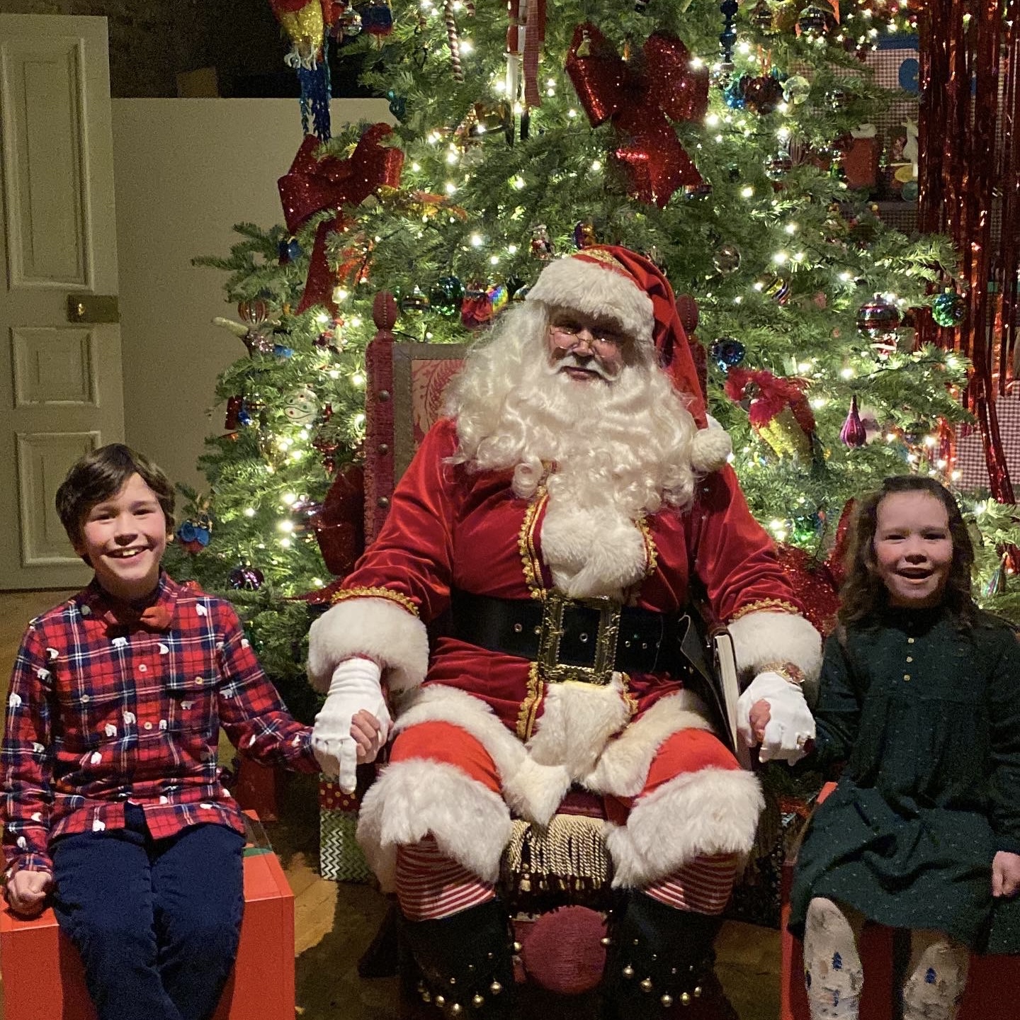 two children laughing with santa