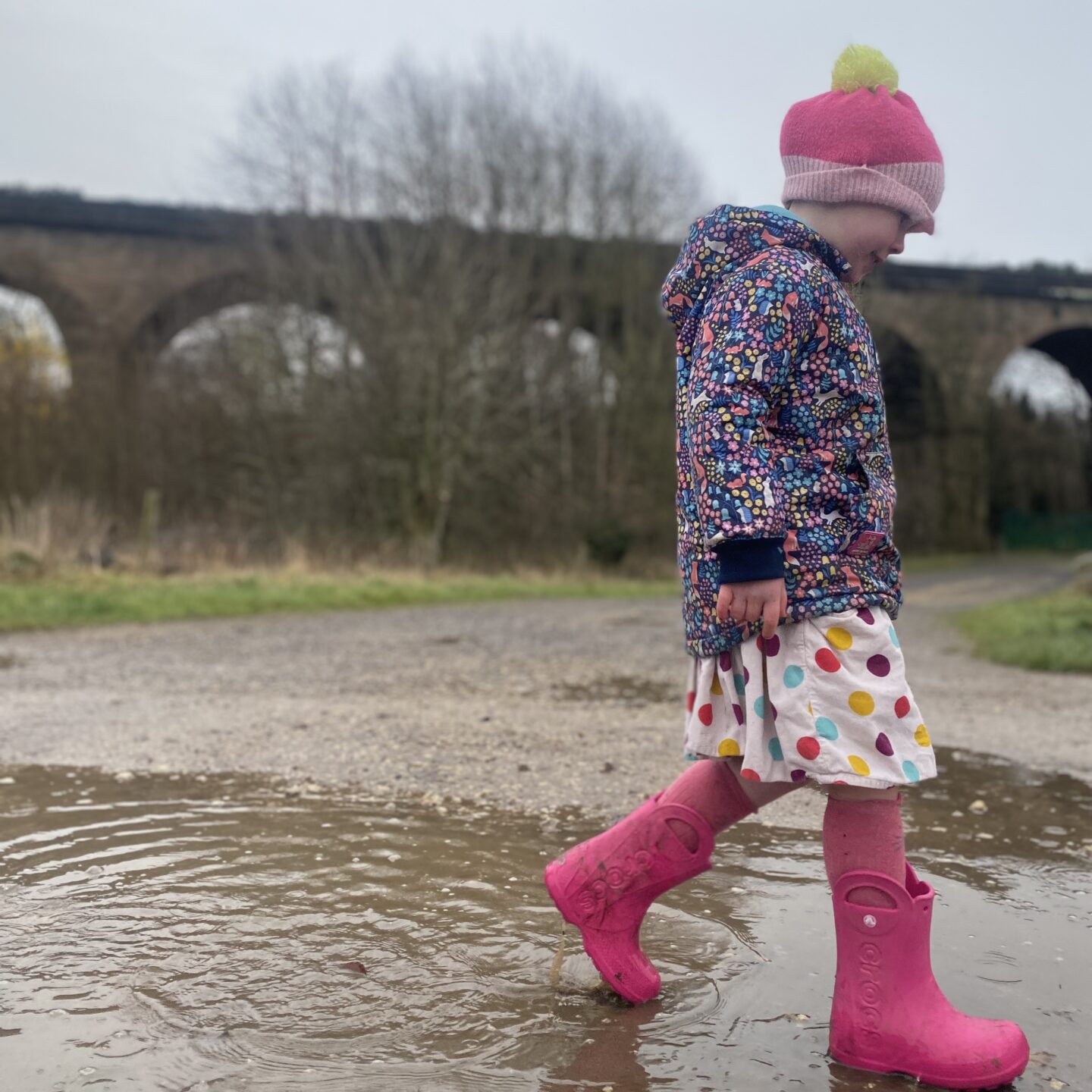 a young girl plodding through puddles 