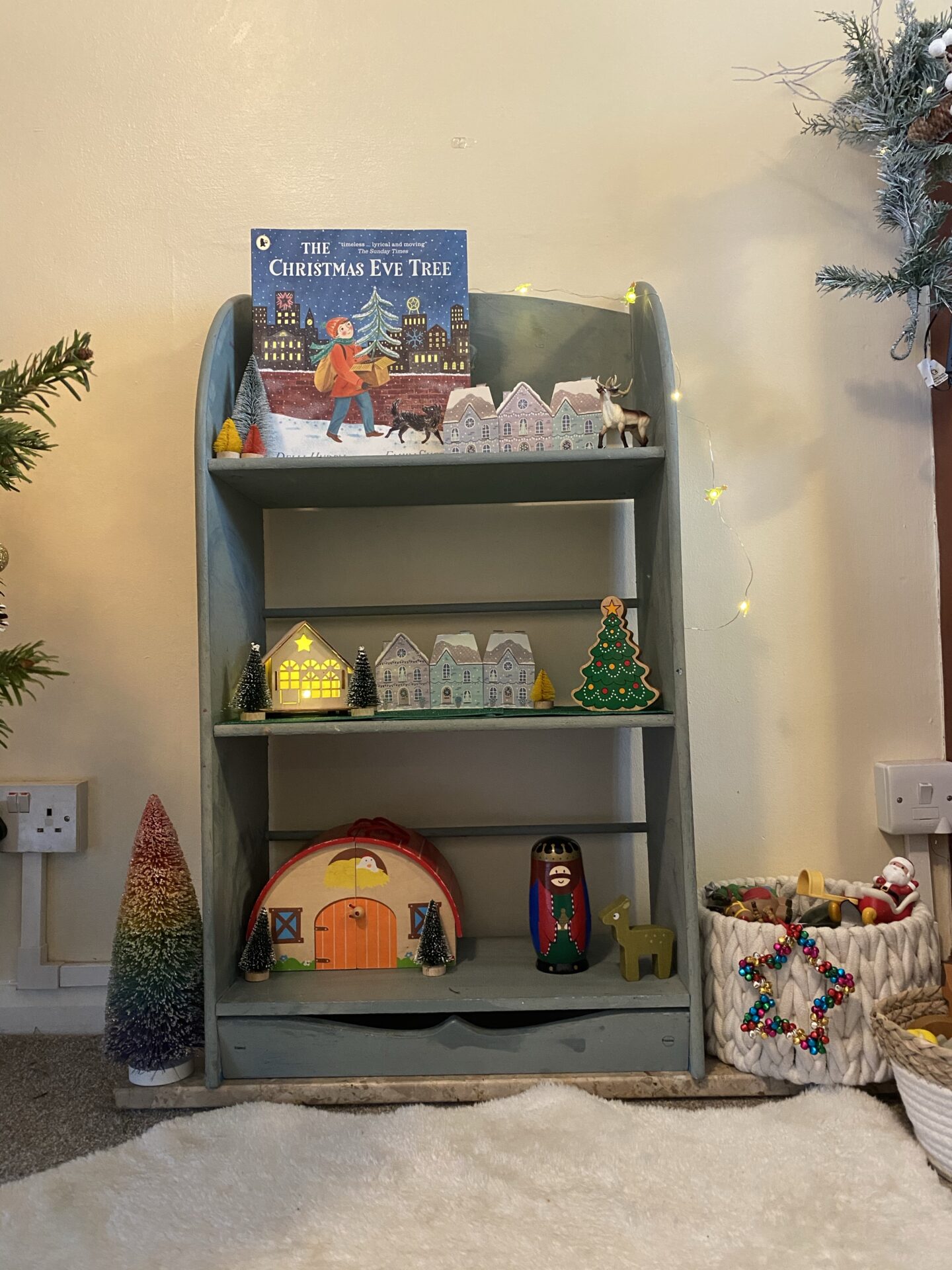 a shelf with Christmas books and decor on it