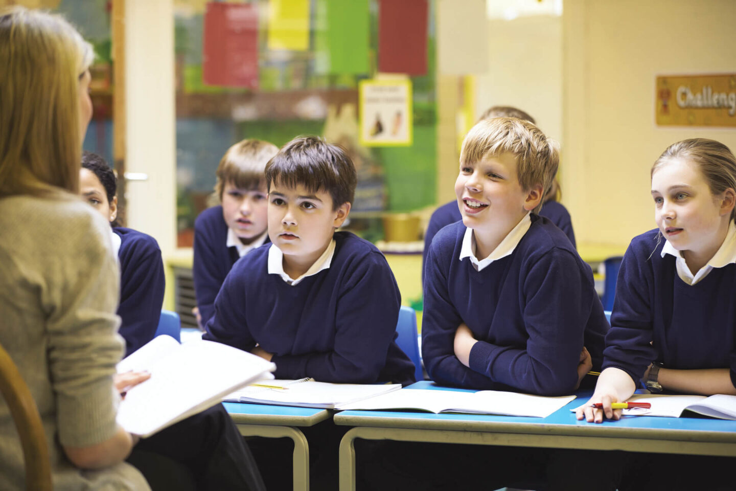 benefits of school uniform - a table of kids sat chatting to a teacher 