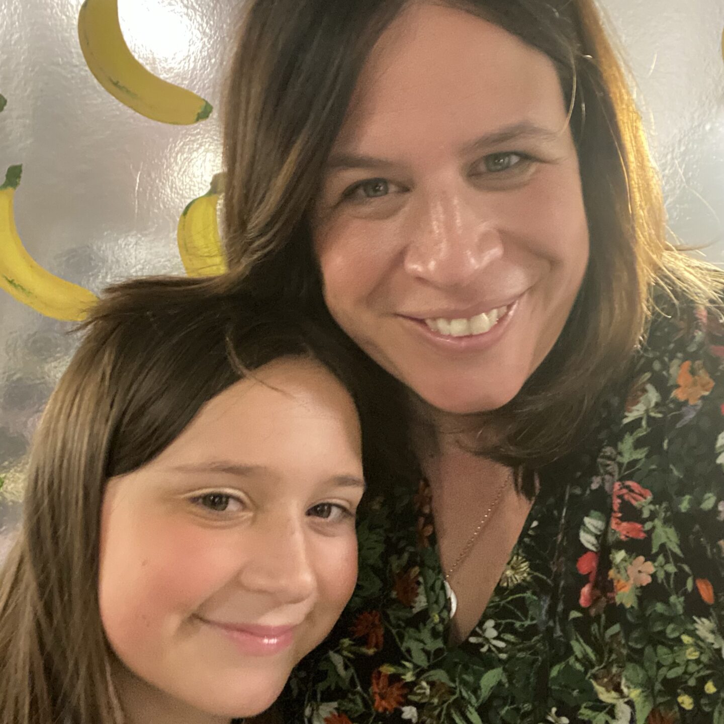 a mum and daughter smiling at the camera