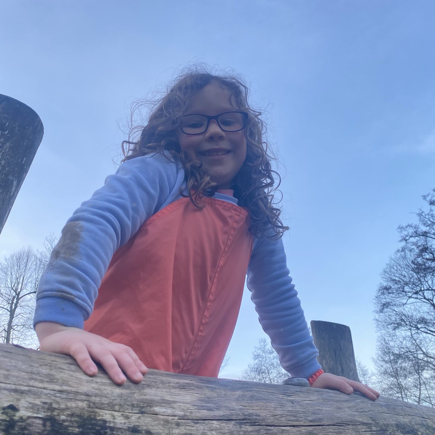 a young girl playing in the park smiling at the camera
