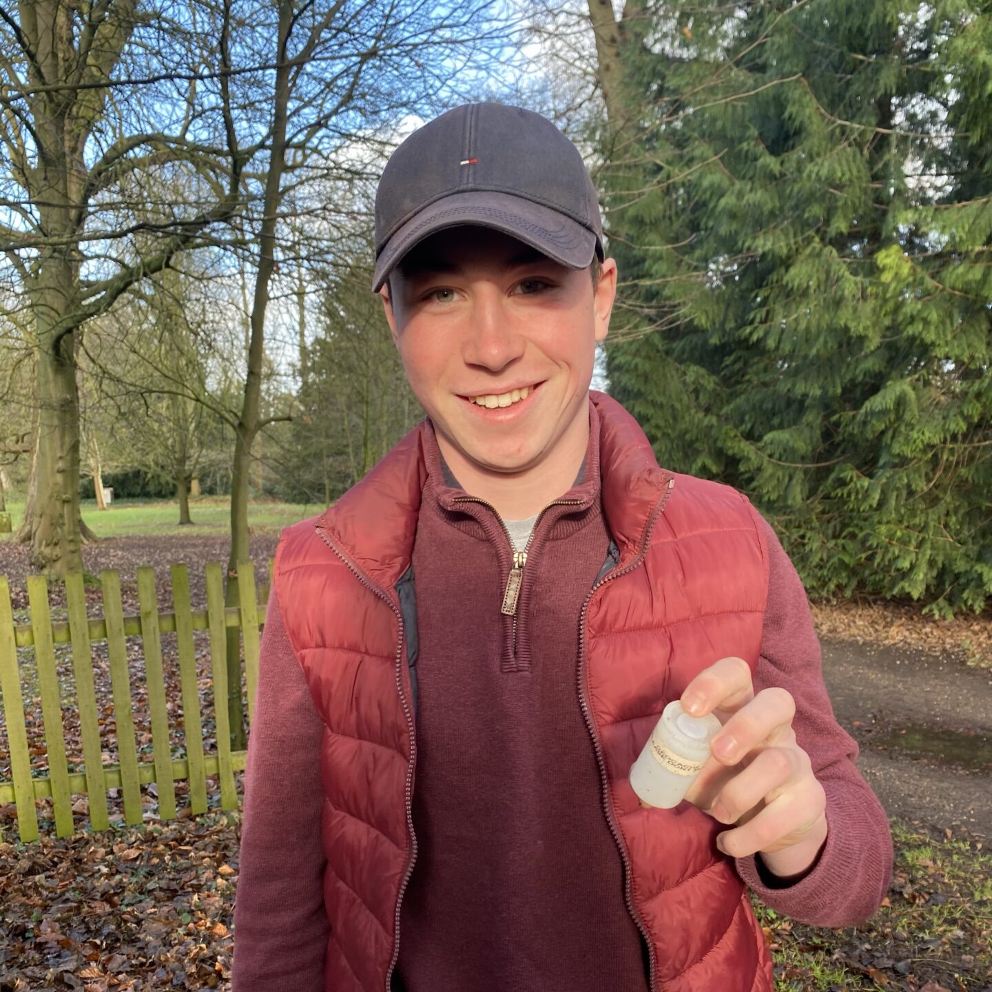 a teenage boy holding a micro geocache 
