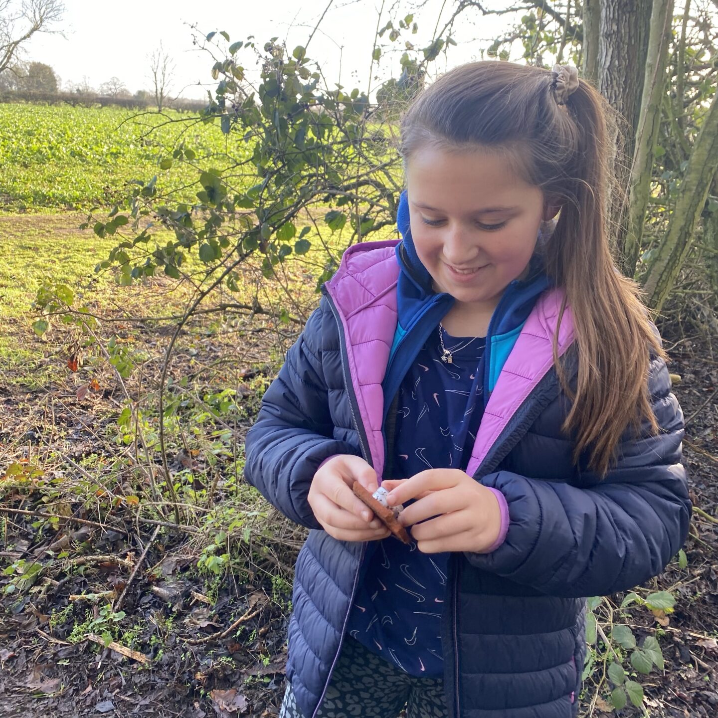 a young girl holding a micro geocache 