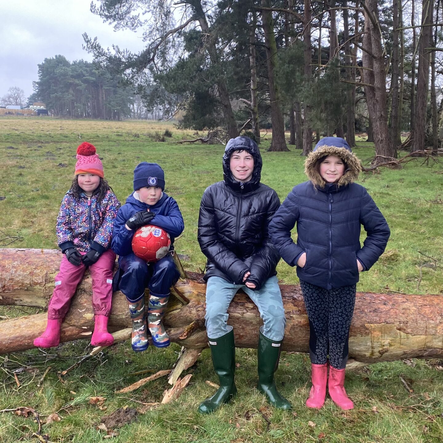 4 children on a log In the rain