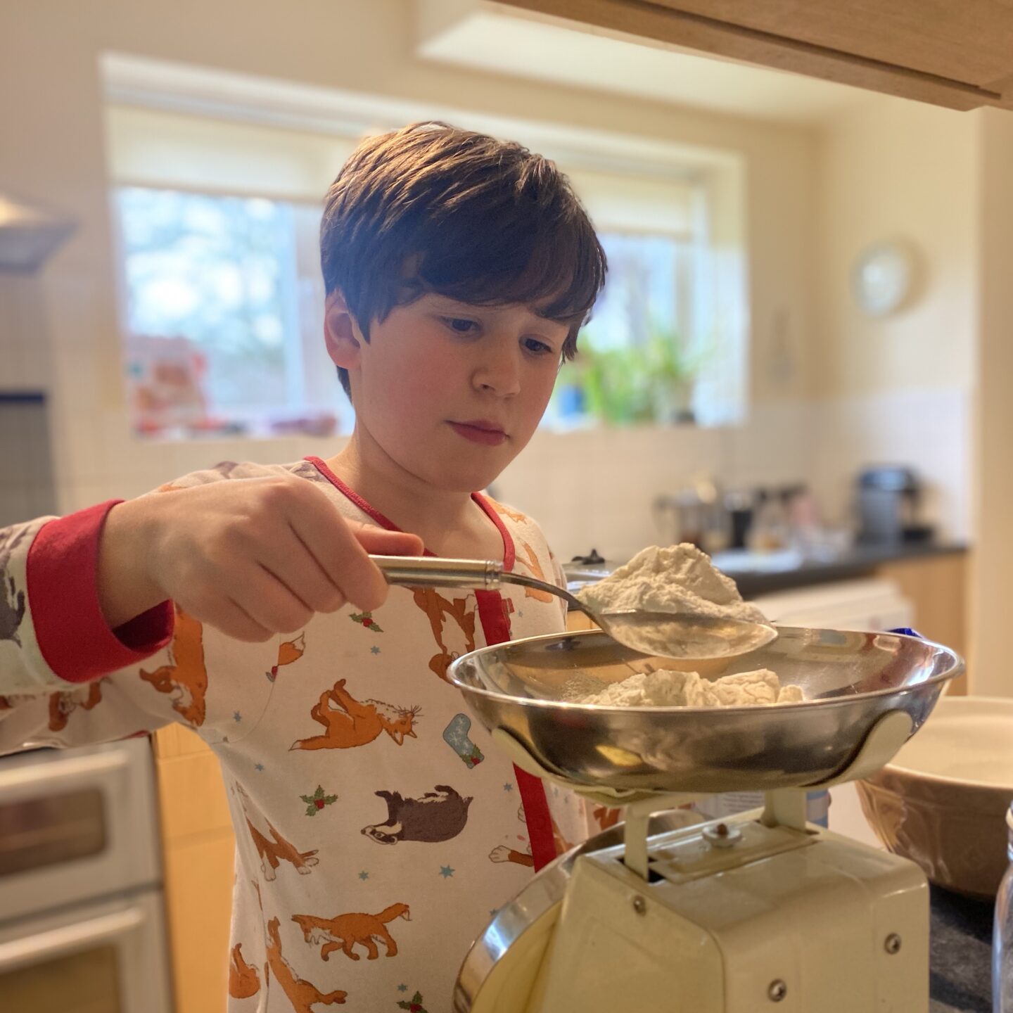 Stormy week - A boy Baking indoors weighing flour out on scales