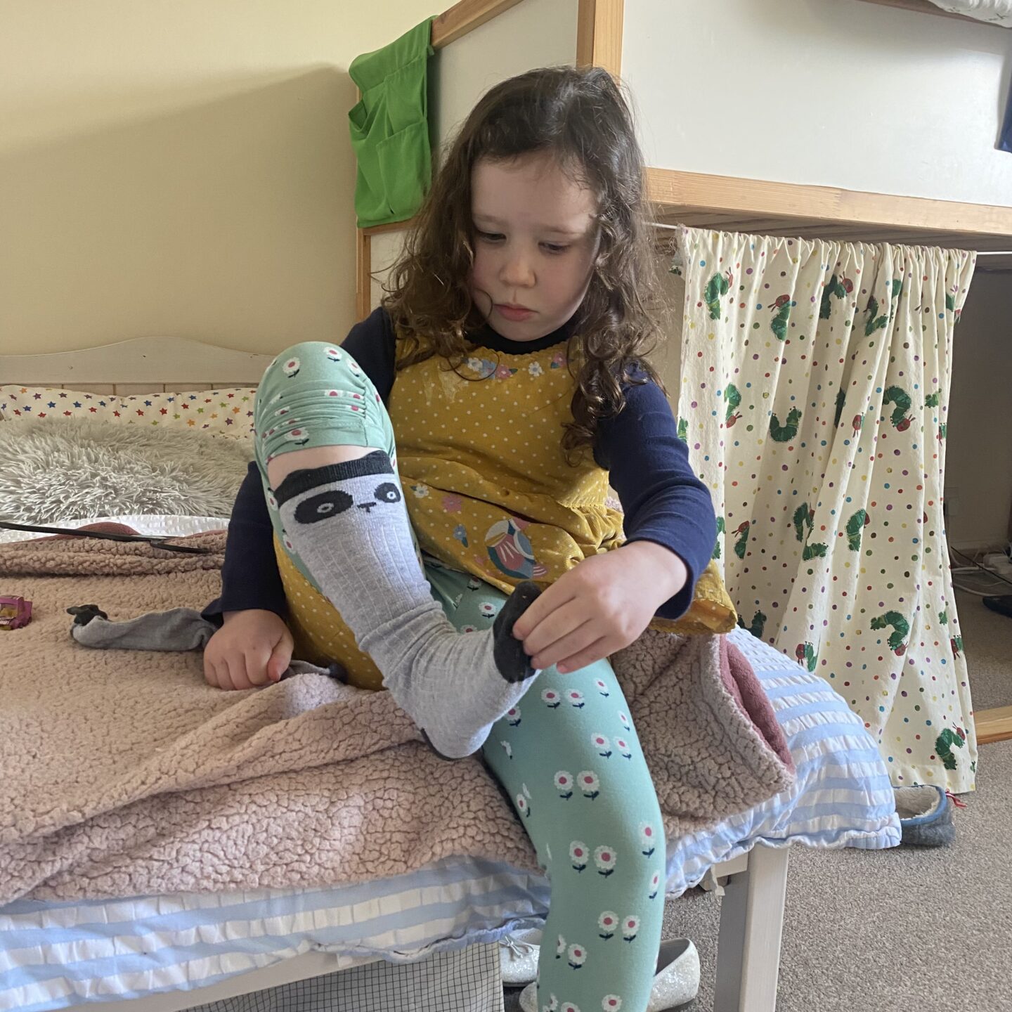 a girl putting on hr socks 