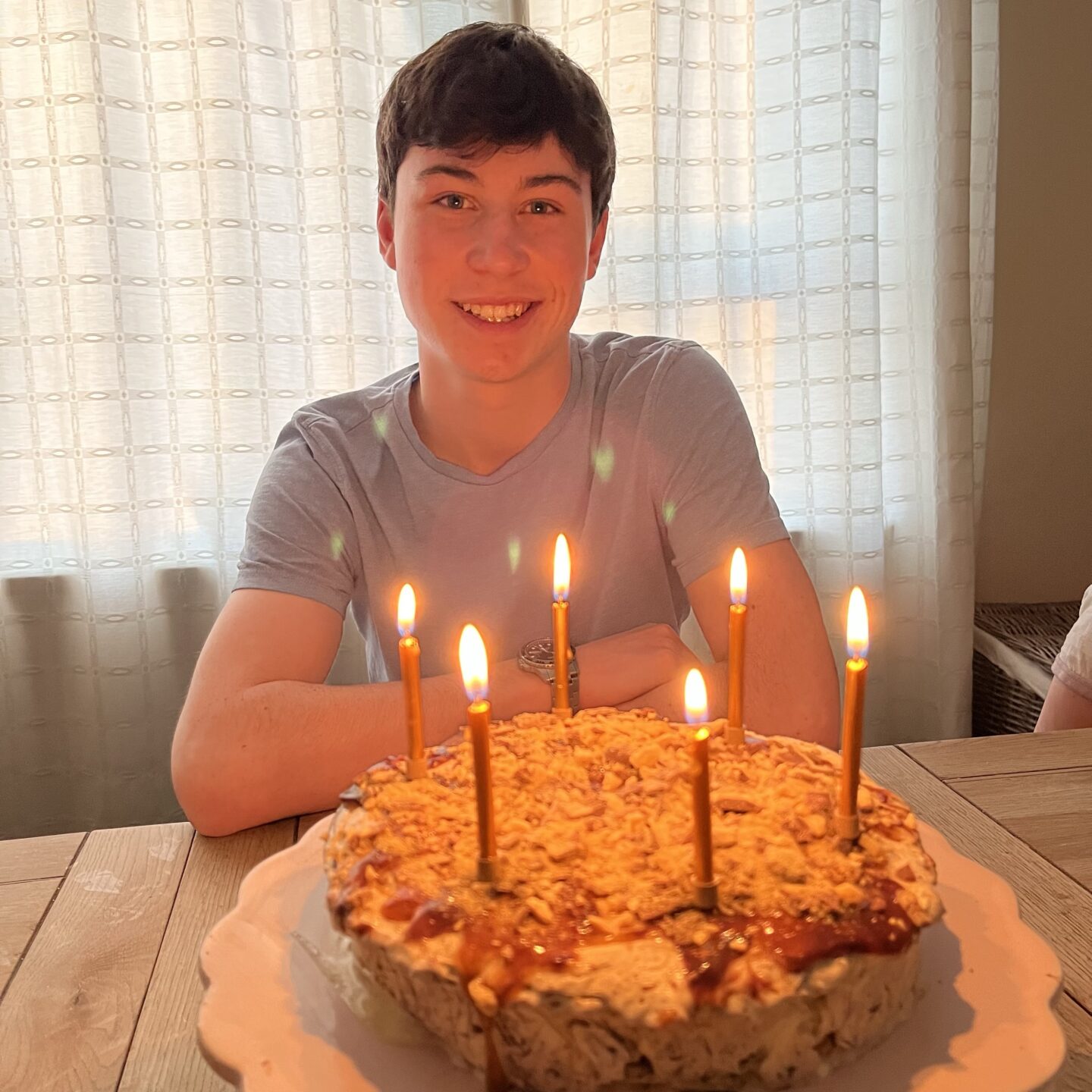 a boy smiling with his birthday cake