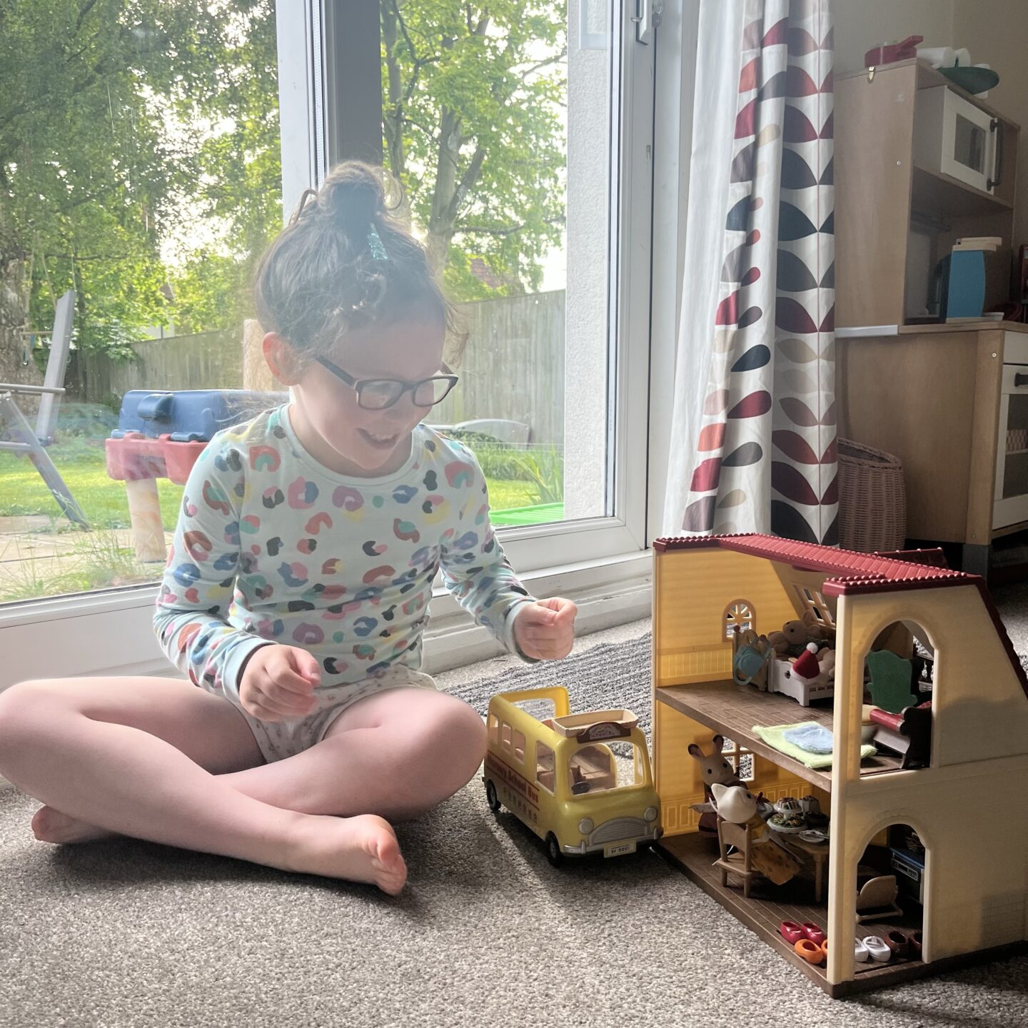 A few little things - a girl say playing with her toys by a patio door