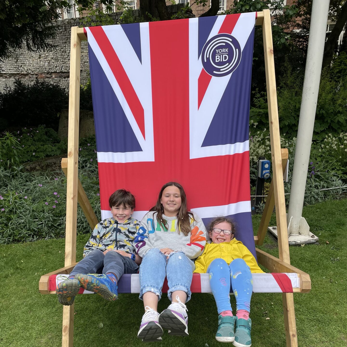 3 kids sat in a deckchair in the York museum gardens