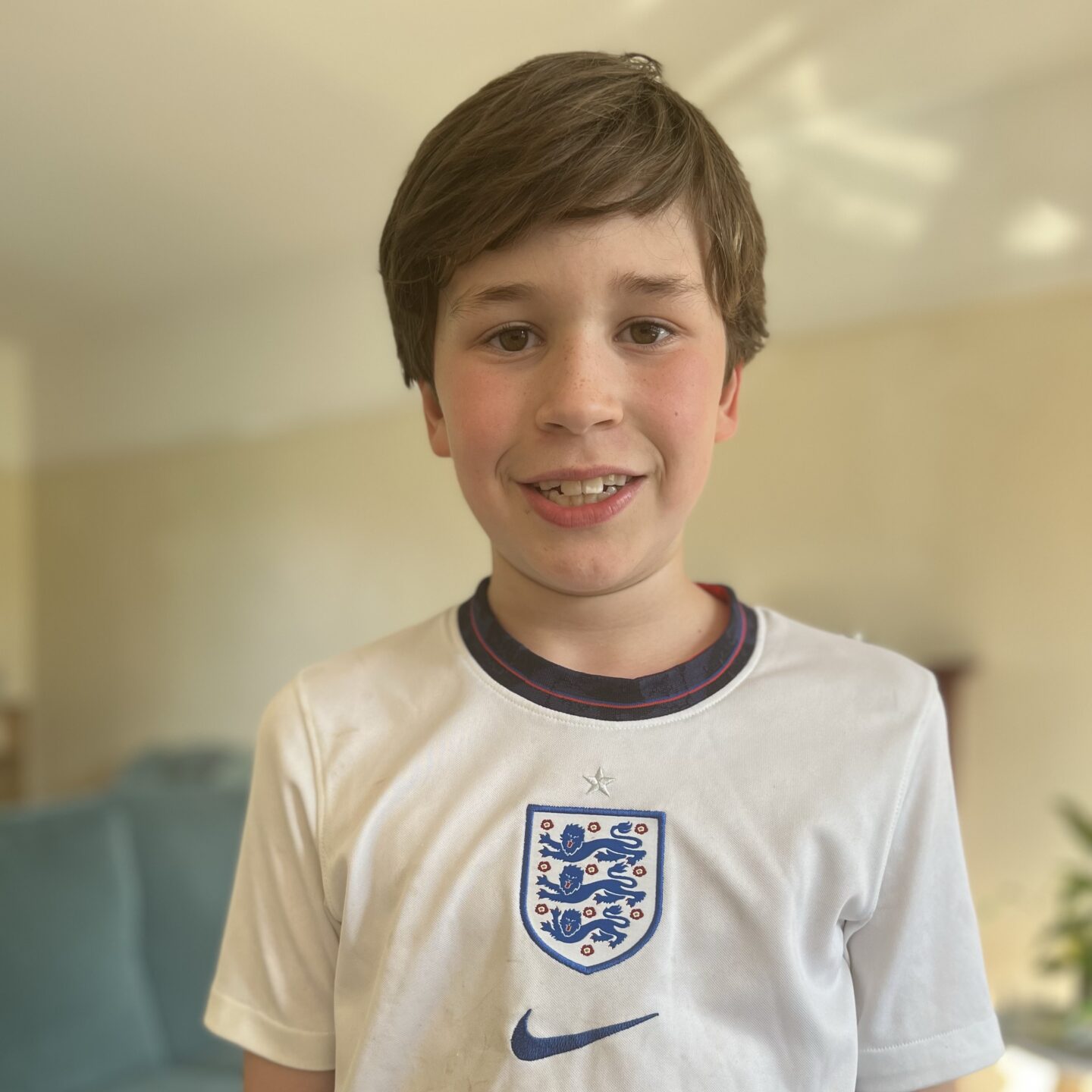 A young boy in sports day clothes smiling at the camera
