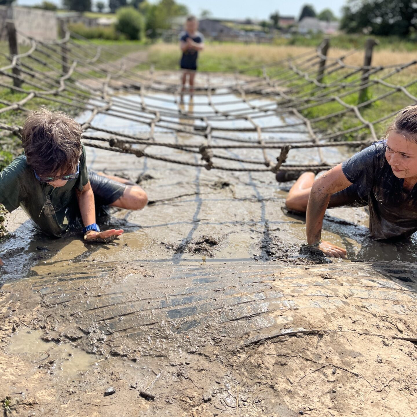 two kids crawling through mud