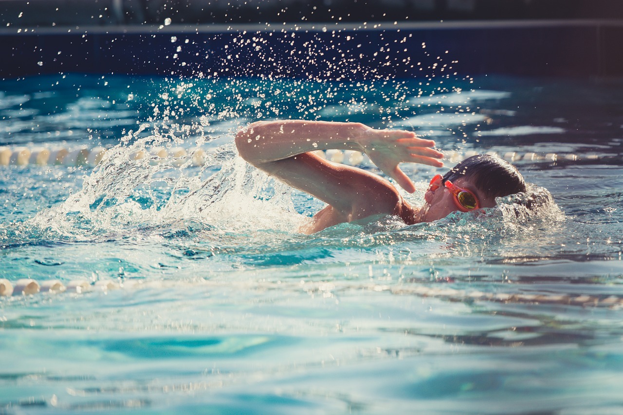 Social Benefits of Extra-Curricular Activities for Children - a boy swimming, doing front crawl with goggles on. 