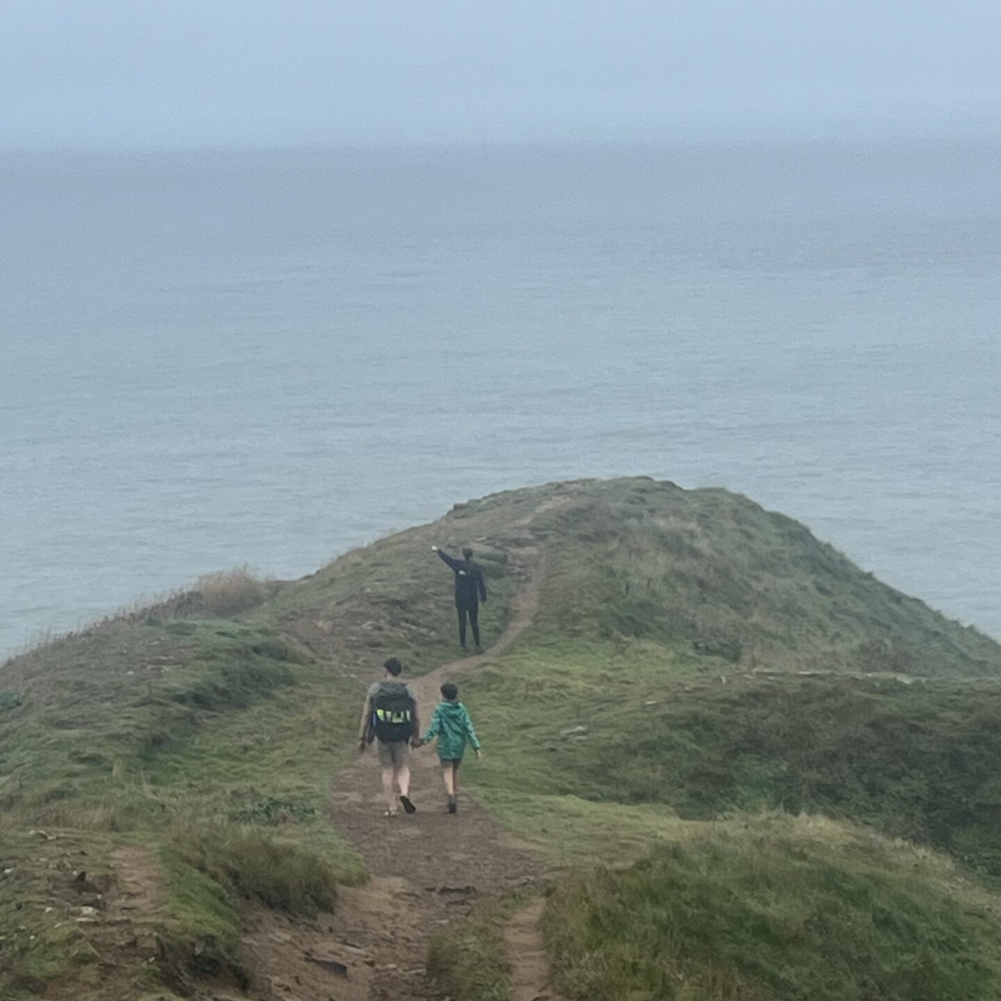 a family walking down to Baggy Point in Devon