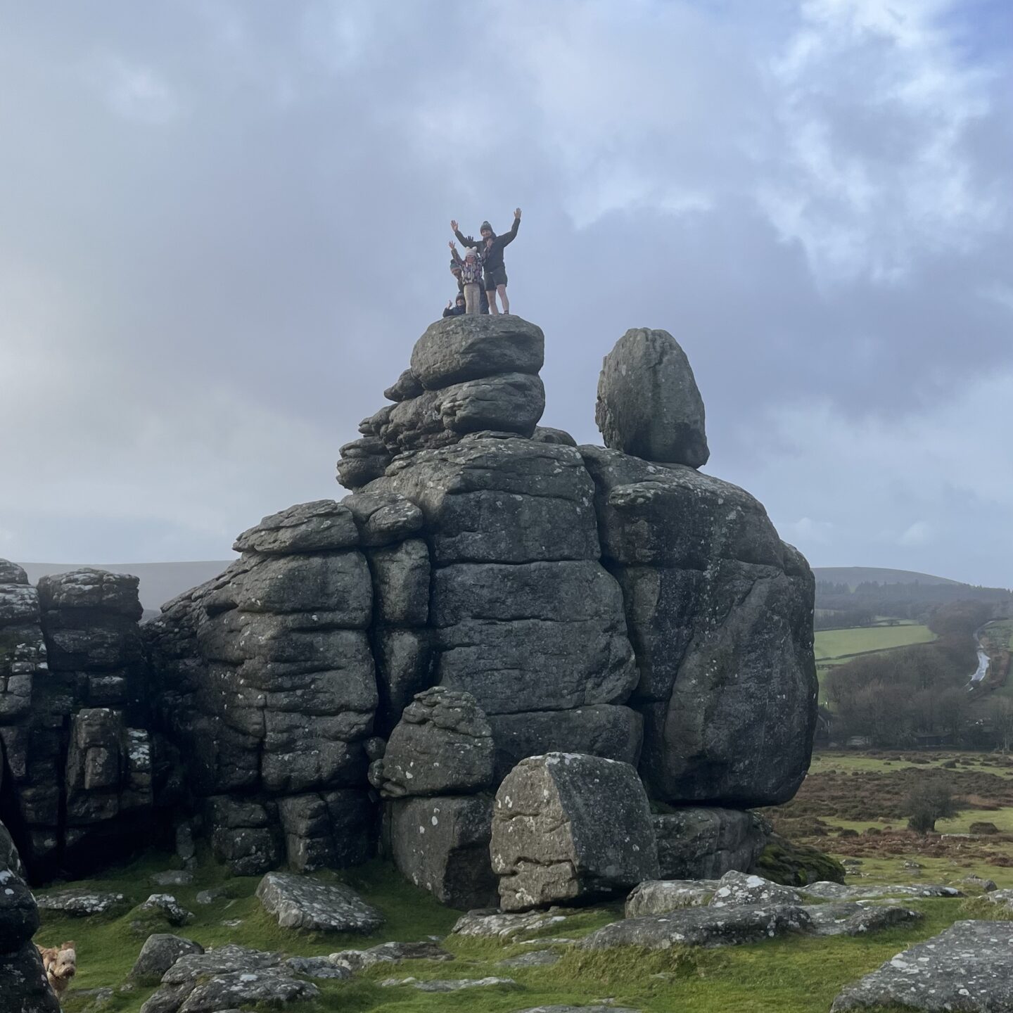  a family stood on top of Hound Tor rocks 