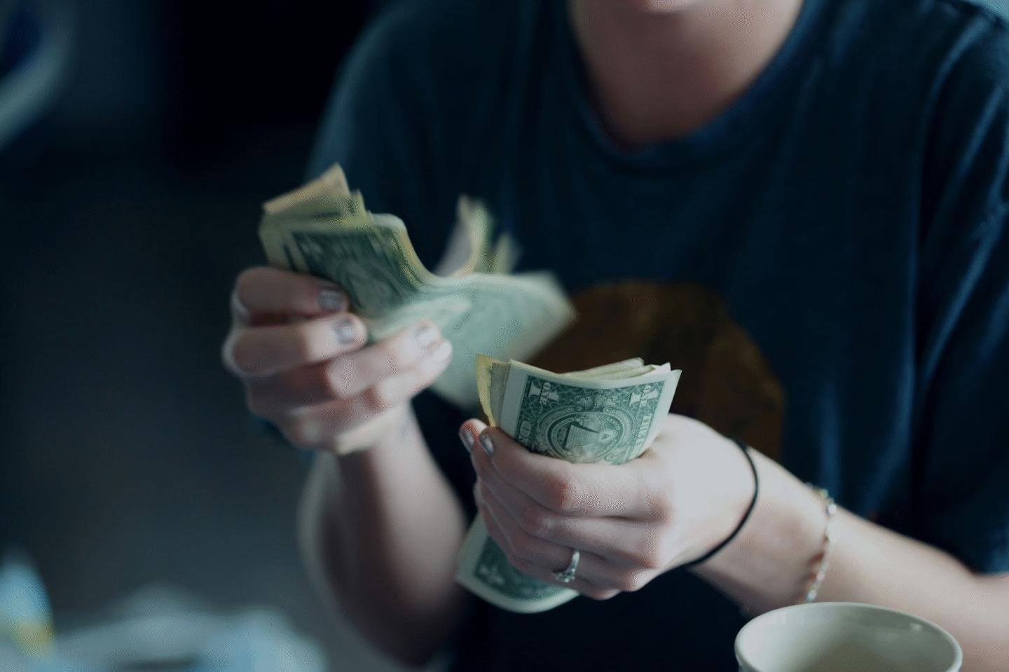 a persons hands holding wads of money notes
