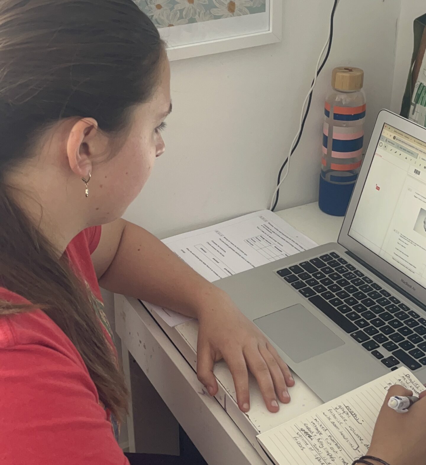 child sat at a desk doing an online tutor session