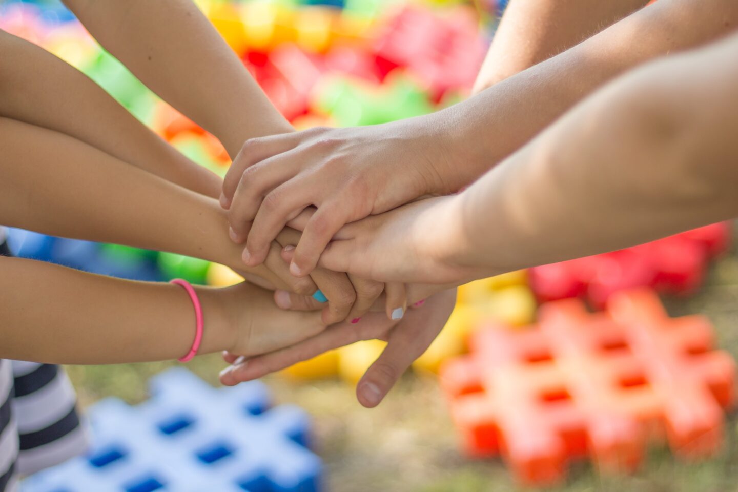 Kids stacking their hands on top of each other for wellbeing classes