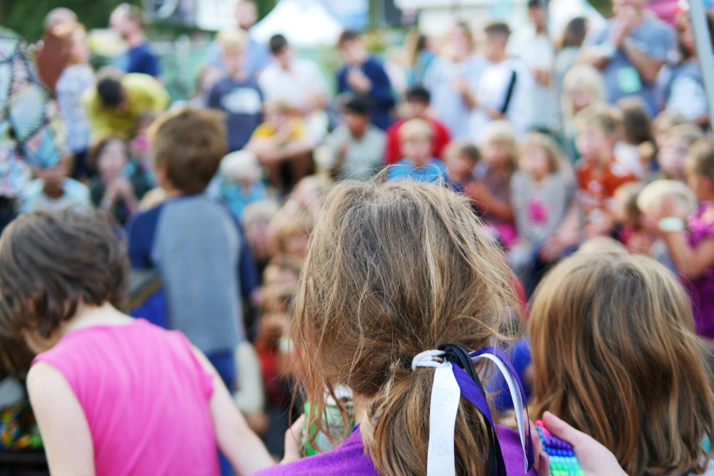 a blurry photo of a crowd of kids with their backs to the camera