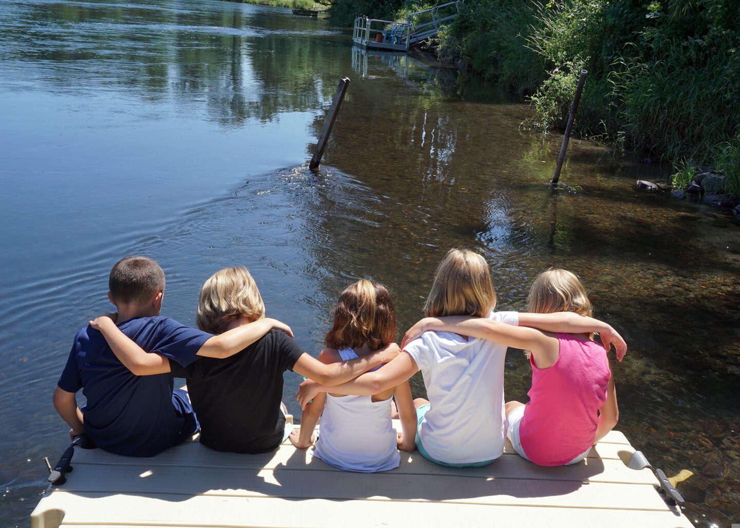 kids goals - 5 kids photographed looking out at a lake with their arms around each other. 